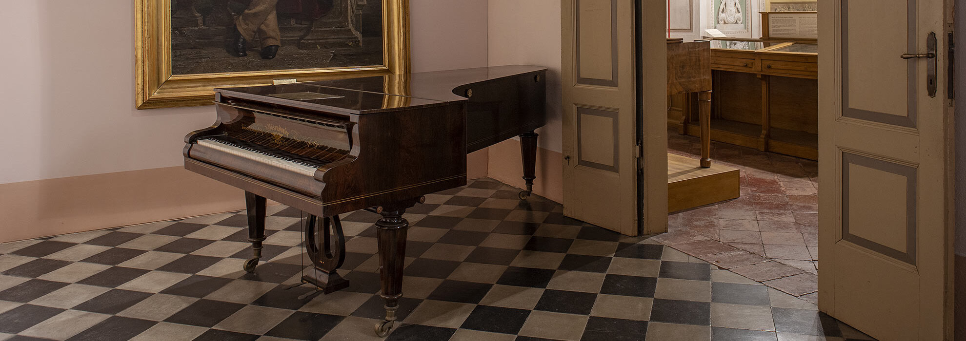 Pianoforte di Gaetano Donizetti con quadro del Maestro in secondo piano
