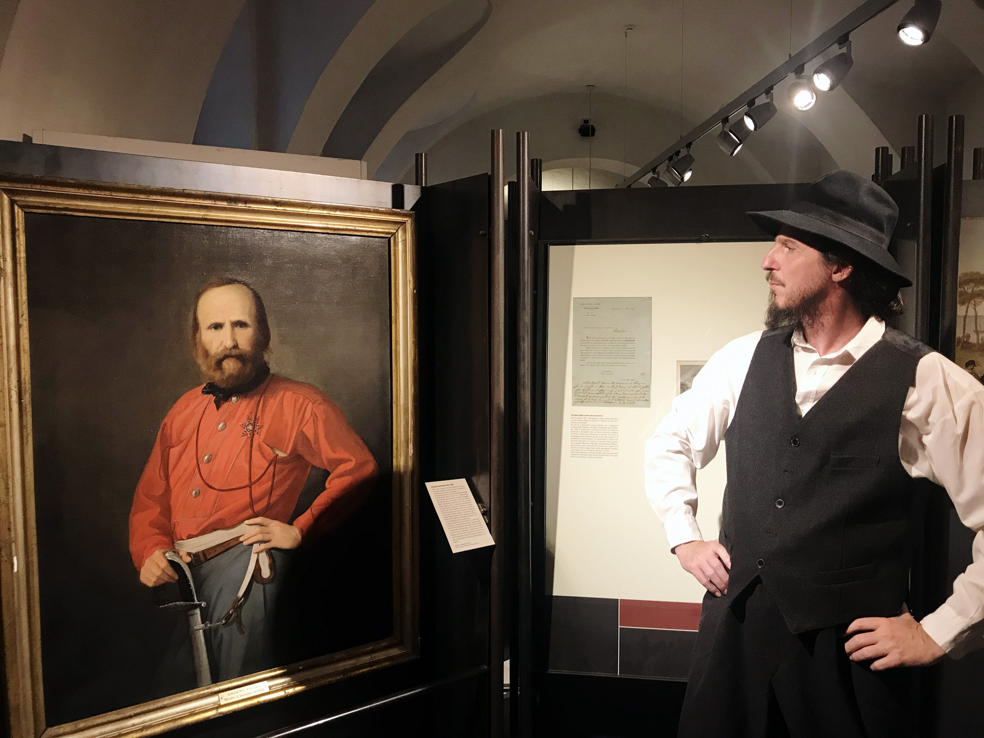 Un attore in posa di fronte al quadro di Giuseppe Garibaldi