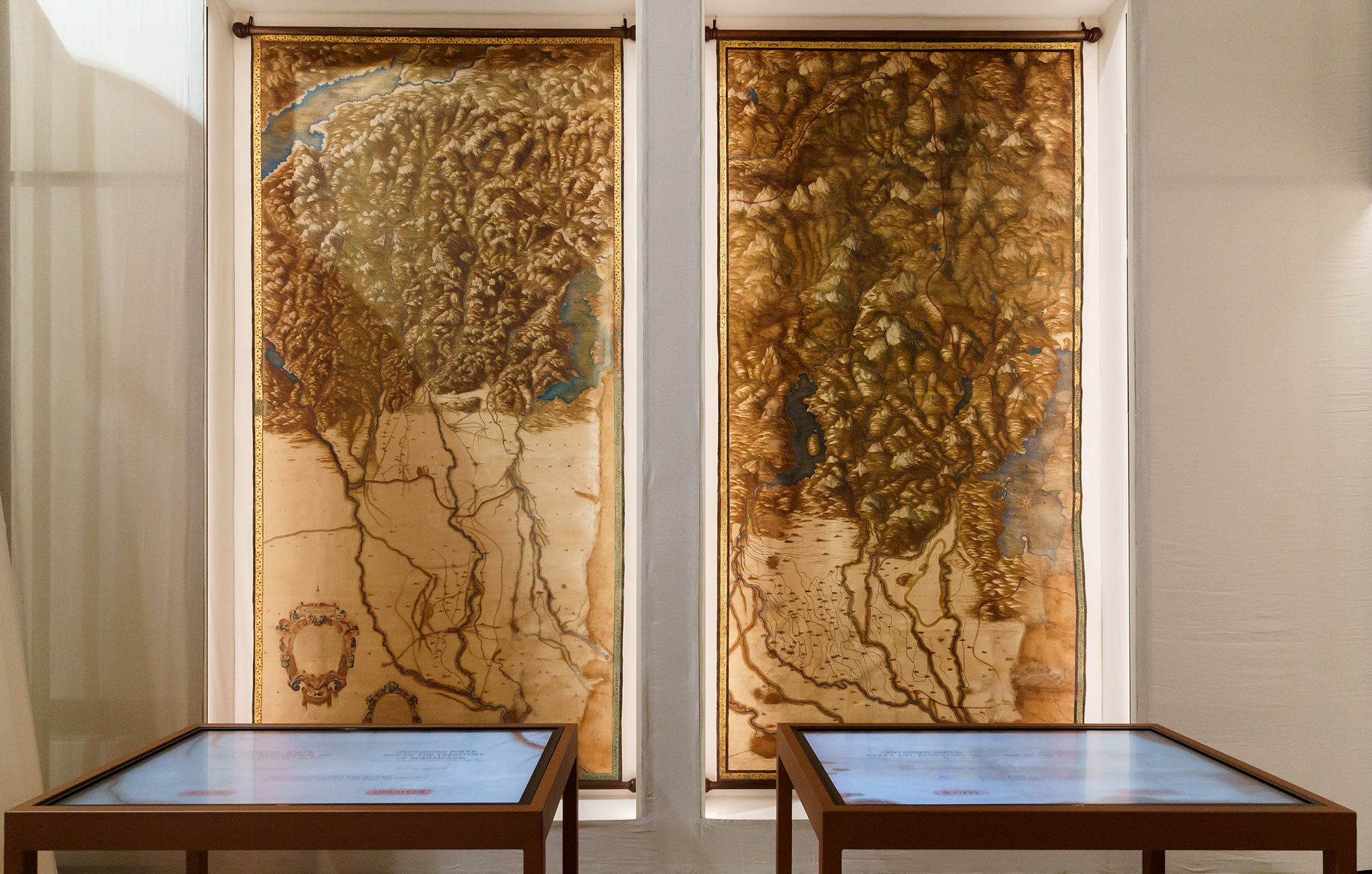 Due carte dei territori di Bergamo e Brescia esposte in mostra. Davanti sono presenti due teche.